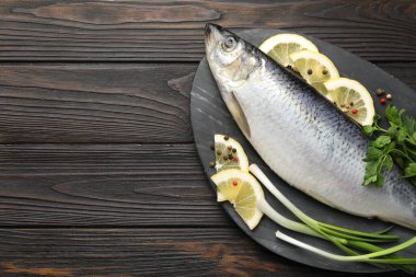 Ahşap masada tuzlanmış ringa balığı ve baharat, üst manzara. Metin için boşluk