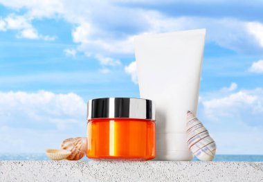 Deniz kenarında güneş kremi ürünleri ve deniz kabukları