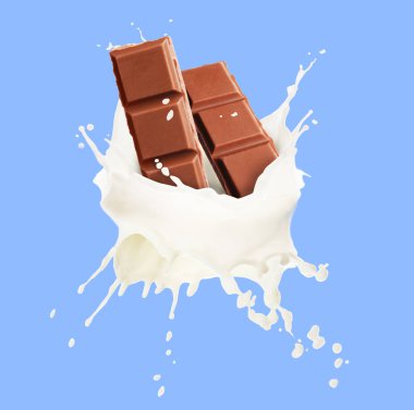 Nefis çikolata parçaları ve açık mavi arka planda havada sütün damlaları.