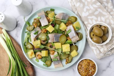 Ringa balıklı lezzetli salata ve beyaz mermer masada malzemeler.