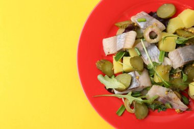 Sarı arka planda ringa balıklı nefis salata, üst manzara. Metin için boşluk