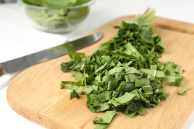 Beyaz ahşap masada taze at ve bıçak kes, yakın plan.