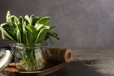 Cam kavanozda taze kuş sürüsü ve gri masada sicim, yakın plan. Metin için boşluk