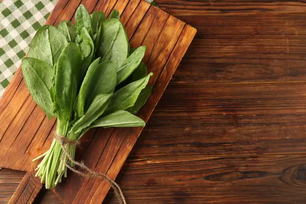 Ahşap masanın üstünde taze yeşil kuş yaprakları var. Metin için boşluk