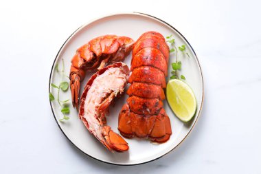 Beyaz masada servis edilen lezzetli haşlanmış ıstakoz kuyrukları.