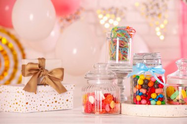 Çikolata. Bir sürü farklı tatlı ve hediye kutuları beyaz ahşap masa üzerinde, şenlikli bir odada.