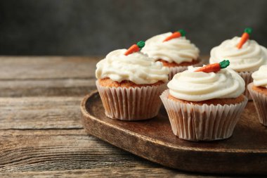 Ahşap masadaki havuçlu kekler gri arka planda, yakın plan. Metin için boşluk