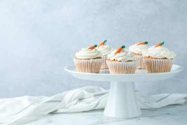 Beyaz mermer masada gri arka planda lezzetli havuçlu kekler. Metin için boşluk