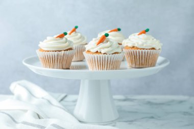 Beyaz mermer masadaki havuçlu kekler gri arka planda, yakın planda.