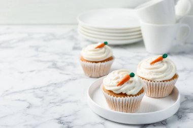 Lezzetli havuçlu kekler beyaz mermer masada, yakın plan. Metin için boşluk