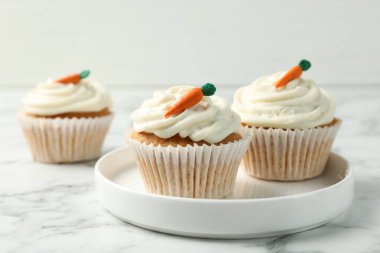 Lezzetli havuçlu kekler beyaz mermer masada, yakın plan.