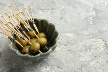 Gri dokulu masada salamura edilmiş zeytinler, yakın plan. Metin için boşluk