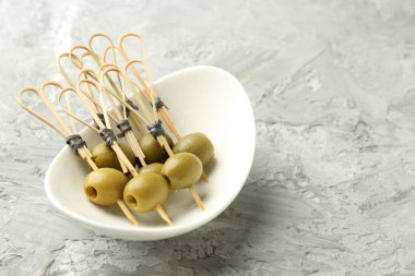 Gri dokulu masada salamura edilmiş zeytinler, yakın plan. Metin için boşluk