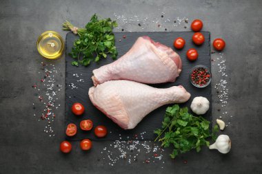 Çiğ hindi budu ve malzemeler gri masada, düz yatıyordu.