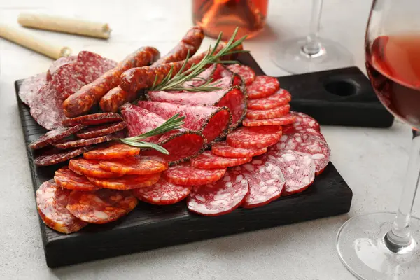 Aydınlık masada farklı tütsülenmiş sosisler servis edilir, yakın plan.