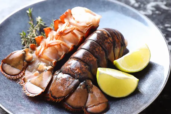 Çiğ ıstakoz kuyruğu, kireç ve kekik masada, yakın plan.