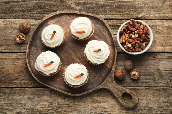 Tahta masanın üzerinde havuçlu kek ve ceviz var.