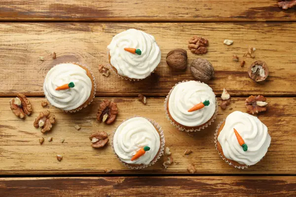 Tahta masanın üzerinde havuçlu kek ve ceviz var.