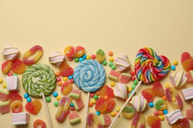 Bej arka planda bir sürü lezzetli şeker ve marşmelov var. Metin için boşluk