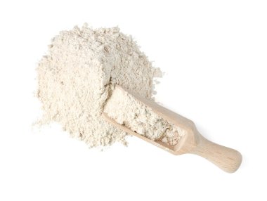 Pile of brown rice flour and scoop isolated on white, top view
