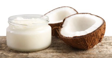 Cam kavanozda organik hindistan cevizi pişirme yağı ve beyaz arka planda ahşap masada taze meyve.