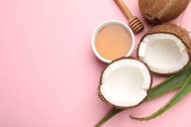 Saç tedavisi. Pembe arka planda taze hindistan cevizi, bal ve aloe yaprakları. Metin için boşluk