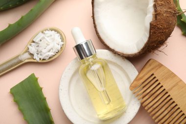 Saç tedavisi. Kozmetik ürünler, hindistan cevizi, tereyağı talaşı ve bej arka planda aloe yaprakları, düz yatış