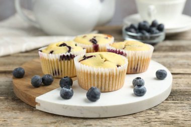 Ahşap masada yaban mersinli lezzetli kekler, yakın plan.