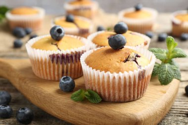 Yaban mersinli lezzetli kekler ve ahşap masada nane şekeri, yakın plan.