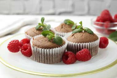 Beyaz masada ahududu ve nane şekerli lezzetli kekler, yakın plan.