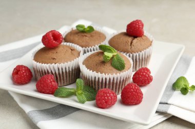 Ahududu ve nane aromalı lezzetli çörekler. Gri desenli masa, yakın plan.