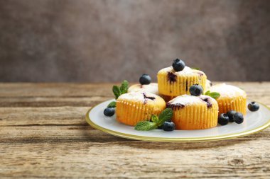 Yaban mersinli lezzetli çörekler, pudra şekeri ve nane şekeri koyu arka planda, yakın plan. Metin için boşluk