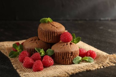 Ahududu ve nane aromalı nefis çörekler, koyu dokulu masa, yakın plan.