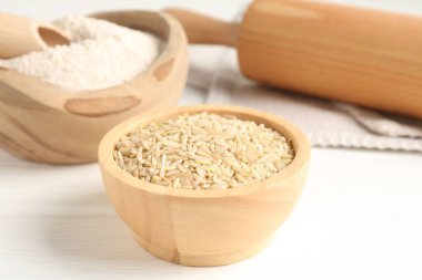 Kahverengi pirinç ve un beyaz ahşap masada, yakın plan.