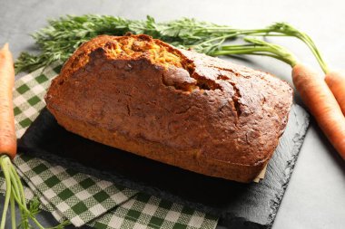 Gri desenli masada havuçlu kek ve sebzeler, yakın plan.