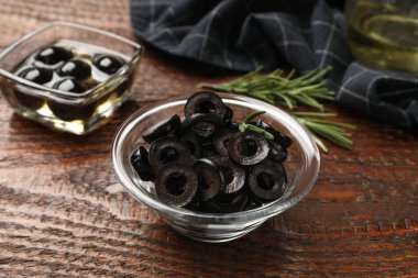 Lezzetli marine edilmiş zeytin halkaları ve ahşap masada biberiye, yakın plan.