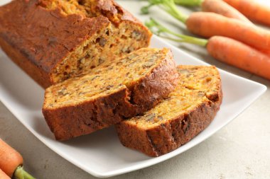 Açık gri masada fındıklı ve sebzeli ev yapımı havuçlu kek, yakın plan.