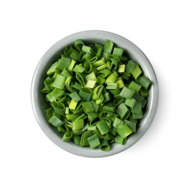 Taze doğranmış yeşil soğan kasede, beyaz manzarada izole edilmiş.