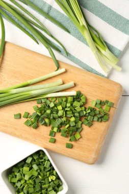 Taze yeşil soğanları beyaz ahşap masada, düz yatıyordu.