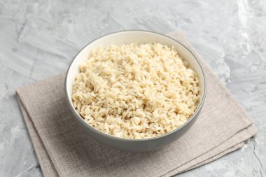 Gri desenli masada servis edilen lezzetli kahverengi pirinç, yakın plan.