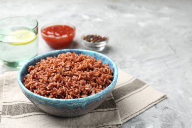 Gri desenli masada servis edilen lezzetli kahverengi pirinç, yakın plan. Metin için boşluk