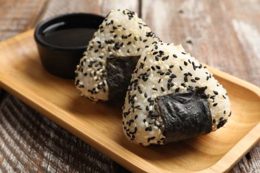 Pirinç topları (onigiri) ve soya sosu ahşap masada, yakın plan. Geleneksel Japon yemeği