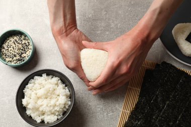 Işık masasında nefis onigiri (Japon pirinç topları) yapan kadın.