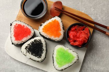 Lezzetli tobiko onigiri (Japon pirinç topları) açık gri masada servis edilir.