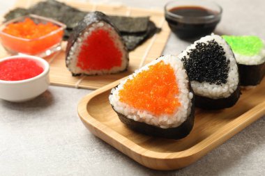 Lezzetli tobiko onigiri (Japon pirinç topları) açık gri masada servis edilir.