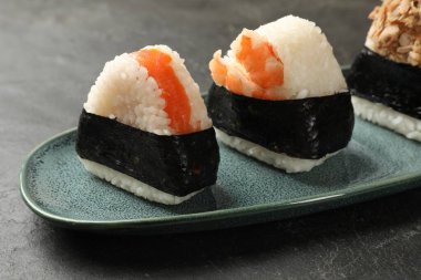 Lezzetli onigiri (Japon pirinç topları) siyah masada servis edilir.