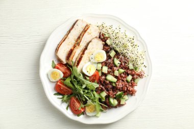 Beyaz ahşap masada kahverengi pirinçli nefis bir salata.