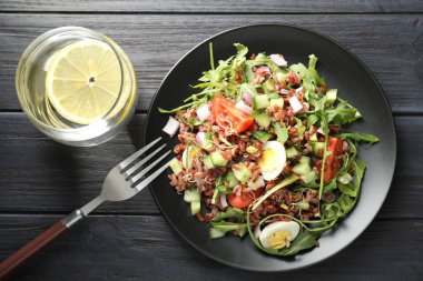 Kahverengi pirinçli nefis salata ve siyah ahşap masada içki.
