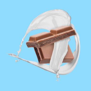 Nefis çikolata parçaları ve açık mavi arka planda havada sütün damlaları.