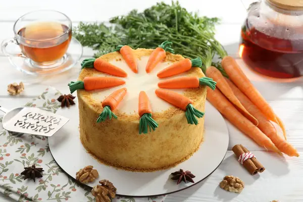 Beyaz ahşap masada servis edilen nefis ev yapımı havuçlu kek.